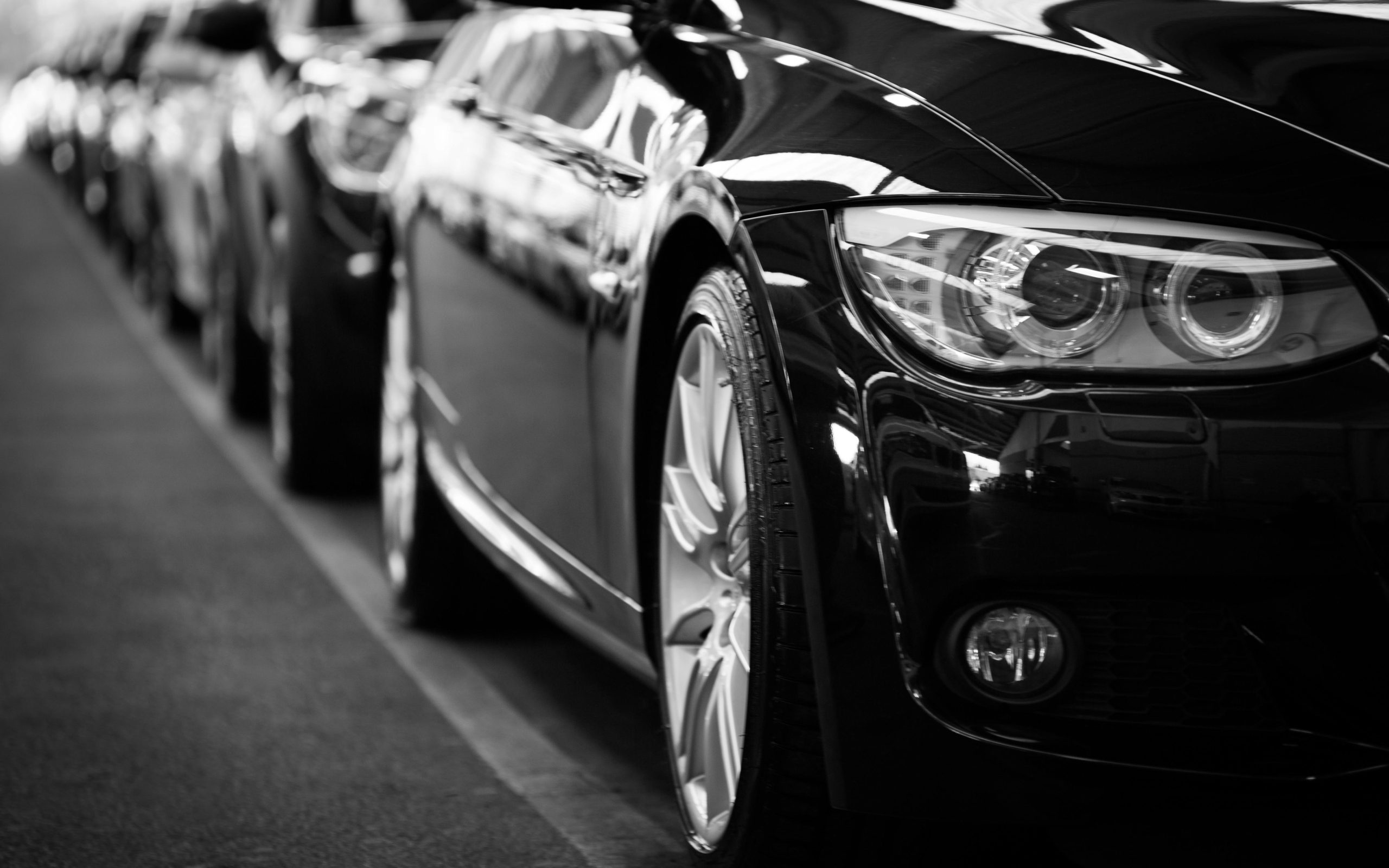 A line of black coupes at a car dealership